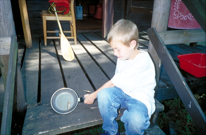 Arian mit seinem ersten Fisch in der Bratpfanne